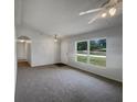 Spacious living room with neutral walls, plush carpet, and large window with outdoor views at 3090 Yorkshire Dr, Deltona, FL 32738