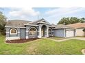Attractive single-story home with lush green lawn, manicured landscaping, and a neutral color scheme at 394 Hickory Springs Pl, Debary, FL 32713