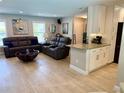 Open-concept living room featuring stylish furniture, modern decor, and seamless transition to the granite counter and white cabinets at 415 Seville Ave, Altamonte Springs, FL 32714