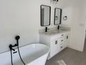 Elegant bathroom with a soaking tub, double vanity, and modern fixtures at 5153 Sw 159Th St, Ocala, FL 34473