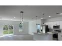 Open-concept kitchen featuring stainless steel appliances and a center island with pendant lighting at 5153 Sw 159Th St, Ocala, FL 34473