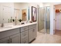 Bathroom featuring a double-sink vanity, modern fixtures, a glass-enclosed shower, and access to a spacious walk-in closet at 519 Silver Palm Dr, Haines City, FL 33844