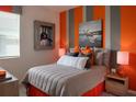 Bedroom design featuring a bed with colorful accents, striped walls, and airplane-themed decor creating a vibrant space at 519 Silver Palm Dr, Haines City, FL 33844