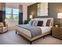 Bedroom showcases a luxurious bed with decorative pillows, stylish lamps, and a calming ambiance enhanced by a large window at 519 Silver Palm Dr, Haines City, FL 33844