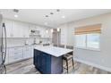 Updated kitchen featuring white cabinetry, stainless steel appliances, a center island with seating, and luxury vinyl flooring at 525 Southport Dr, Longwood, FL 32750