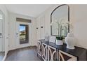 Inviting foyer features stylish decor, a decorative console table, an arch mirror, and a view of the home's exterior at 5868 Galloping Dr, Apopka, FL 32712
