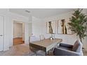 Well-lit home office featuring a modern desk, plush chairs, neutral decor, and a view of adjacent rooms at 5868 Galloping Dr, Apopka, FL 32712