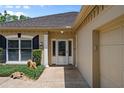 Close-up of a home's entry, showcasing a glass door, sidelights, and manicured shrubs at 5973 Chesapeake Park # 58, Orlando, FL 32819