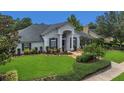Beautiful single-story home boasting a lush lawn, mature trees, and tasteful landscaping at 605 Macglenross Dr, Oviedo, FL 32765