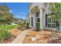 Inviting front entrance with a stone walkway, stately columns, and a cozy seating area at 605 Macglenross Dr, Oviedo, FL 32765