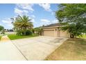 Driveway leading to charming single-story home with a two-car garage, showcasing ample parking space at 611 Curly Fern Ln, Deland, FL 32720