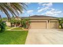 Charming single-story home featuring a fountain, a well-manicured lawn, and an attached two-car garage at 611 Curly Fern Ln, Deland, FL 32720