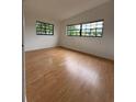 Bright bedroom featuring hardwood flooring and sunlit windows, creating a warm and inviting space at 6615 Beamer Way, Orlando, FL 32807