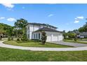 Side view of elegant modern home with a three-car garage, green lawn and beautifully landscaped garden at 734 Terra Pl, Maitland, FL 32751