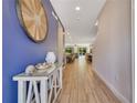 Inviting entryway with wood tile flooring, blue accent wall, and stylish decorative elements at 7647 Fairfax Dr, Kissimmee, FL 34747