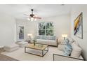 Bright living room with neutral decor, ceiling fan, and view of wooded landscape at 8824 Villa View Cir # 204, Orlando, FL 32821