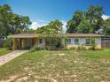 Charming single-story home with a lush front yard, mature trees, and a covered carport showcasing curb appeal at 920 Gloriosa Ave, Winter Park, FL 32789