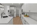 Bright kitchen with stainless steel appliances, white cabinets, quartz countertops, and a walk-in pantry at 1002 Farmstead St, Eustis, FL 32736