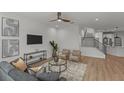 Inviting living room featuring a comfortable gray sofa, modern furnishings, and a staircase at 1002 Farmstead St, Eustis, FL 32736