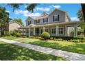 Charming two-story home featuring a spacious front porch, manicured lawn, and beautiful landscaping at 10100 Loblolly Pine Cir, Orlando, FL 32827