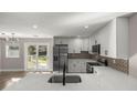 Modern kitchen with quartz countertops, stainless steel refrigerator, and stylish backsplash at 11572 Se 60Th Ave, Belleview, FL 34420