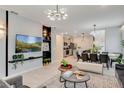 Open-concept living space featuring a modern chandelier, decorative wall, and seamless flow to the kitchen and dining area at 1221 Aloha Blvd, Davenport, FL 33897