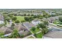 Aerial view of a neighborhood showcasing the property's fenced backyard with mature trees and solar panels at 12691 Calderdale Ave, Windermere, FL 34786
