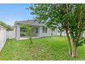 Backyard showcasing a well-maintained lawn, with a view of the home's screened-in patio at 12691 Calderdale Ave, Windermere, FL 34786