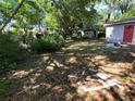 Large, foliage covered backyard with outbuilding, offering ample space and privacy at 1420 Bethesda St, Apopka, FL 32703