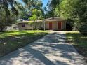 Inviting single-story home featuring a well-maintained lawn, covered parking, and mature trees at 1420 Bethesda St, Apopka, FL 32703