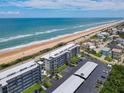 Beautiful aerial view of the beachfront condos with covered parking and adjacent neighborhood at 3100 Ocean Shore Blvd # 4030, Ormond Beach, FL 32176
