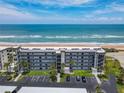 Aerial shot of beachfront condo with balconies, covered parking and lush landscaping at 3100 Ocean Shore Blvd # 4030, Ormond Beach, FL 32176
