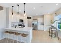 Bright, modern kitchen features white cabinetry, a center island with seating, and stainless steel appliances at 3156 Emerald Acres Ln, Sanford, FL 32771