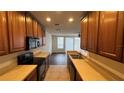 Kitchen featuring stainless appliances and ample countertop space, with a view of living area at 3166 Riachuelo Ln, Kissimmee, FL 34744