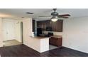 Open-concept kitchen with dark cabinetry, modern appliances, and a breakfast bar for casual dining at 3166 Riachuelo Ln, Kissimmee, FL 34744