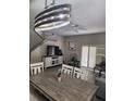 Bright dining area with a wooden table, stylish light fixture, and plantation shutters at 3500 Calabria Ave, Davenport, FL 33897