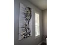 Close-up of a black and gold abstract art piece and white window shutters at 3500 Calabria Ave, Davenport, FL 33897