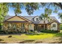 Charming home with stone accents, a well-manicured lawn, and mature landscaping at 40137 County Road 452, Leesburg, FL 34788