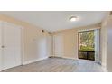 Bright living room featuring neutral paint, wood-look flooring, and a large window at 419 Sheoah Blvd # 27, Winter Springs, FL 32708