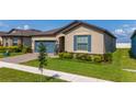 Charming single Gathering home featuring a blue garage door and shutters with a well-manicured lawn at 426 Citrus Isle Loop, Davenport, FL 33837