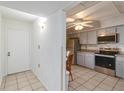 Bright kitchen with stainless steel appliances, tiled floor, and a view into the dining area at 6 Escondido Cir # 55, Altamonte Springs, FL 32701