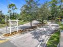 Scenic view of winding road leading into the Bay Forest at Pelican Landing community entrance with lush trees at 600 Garden Club Dr, Deland, FL 32724