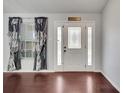 Inviting entryway featuring a decorative glass door, sidelights, dark hardwood floors, and elegant curtains at 6017 Brookhill Ct, Orlando, FL 32810
