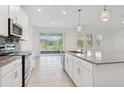 Bright kitchen with stainless steel appliances, island, and sliding door access to outdoors at 6139 Claystone Way, Mount Dora, FL 32757