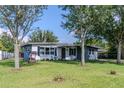 Single-story home with a lush green lawn, mature trees providing shade, and a charming wishing well at 6203 Candlewood Ln, Orlando, FL 32809