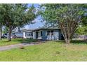 Lovely single-story home with mature trees, a green lawn, and a welcoming pathway to the front door at 6203 Candlewood Ln, Orlando, FL 32809
