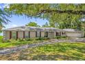 Charming single-story home with a mature landscaped front yard and red window shutters at 633 Balmoral Rd, Winter Park, FL 32789