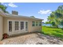 Rear exterior view of home with brick patio and French doors leading to backyard at 633 Balmoral Rd, Winter Park, FL 32789