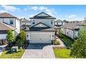 Charming two-story home showcasing manicured landscaping, a gray color scheme, and a two-car garage at 7745 Somersworth Dr, Kissimmee, FL 34747