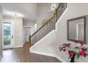 Elegant foyer featuring wood-look floors, staircase with decorative railings, and a stylish mirror at 7745 Somersworth Dr, Kissimmee, FL 34747